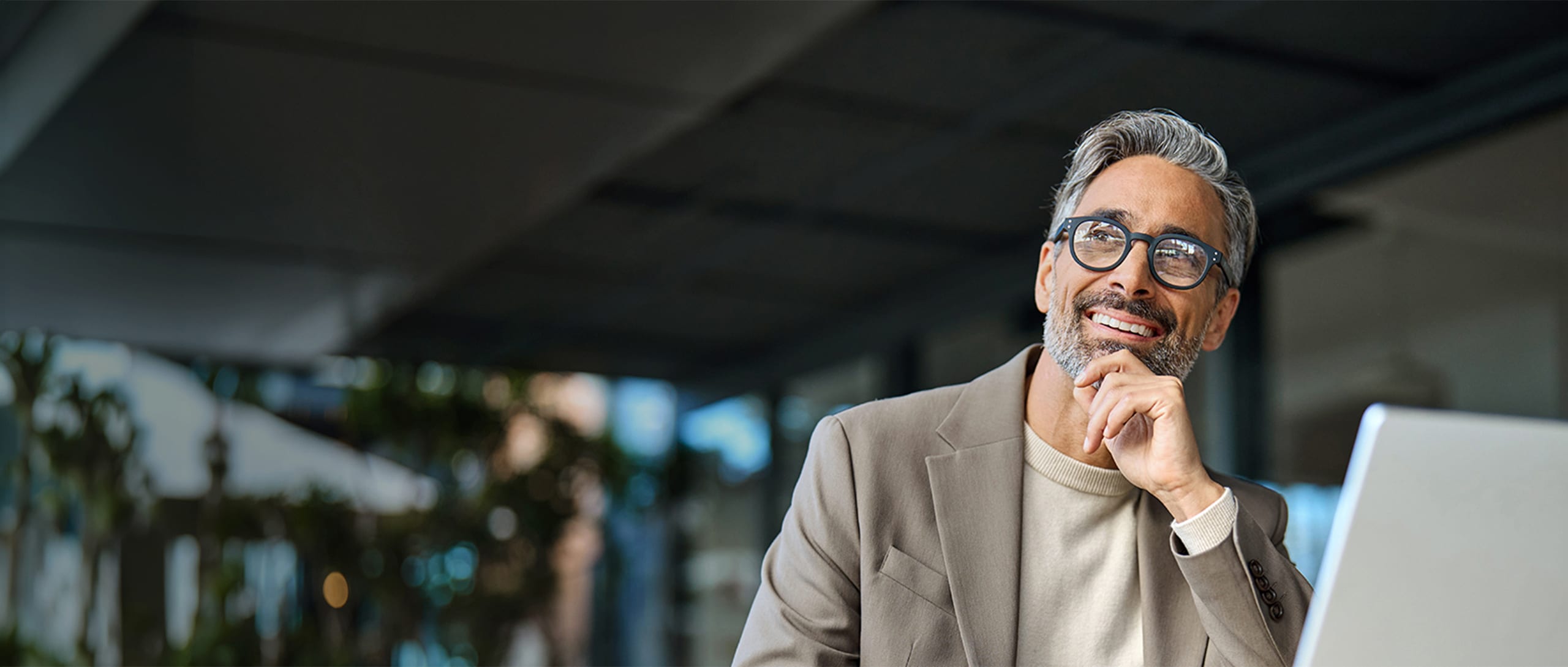 A man wearing black-framed glasses, smiling.