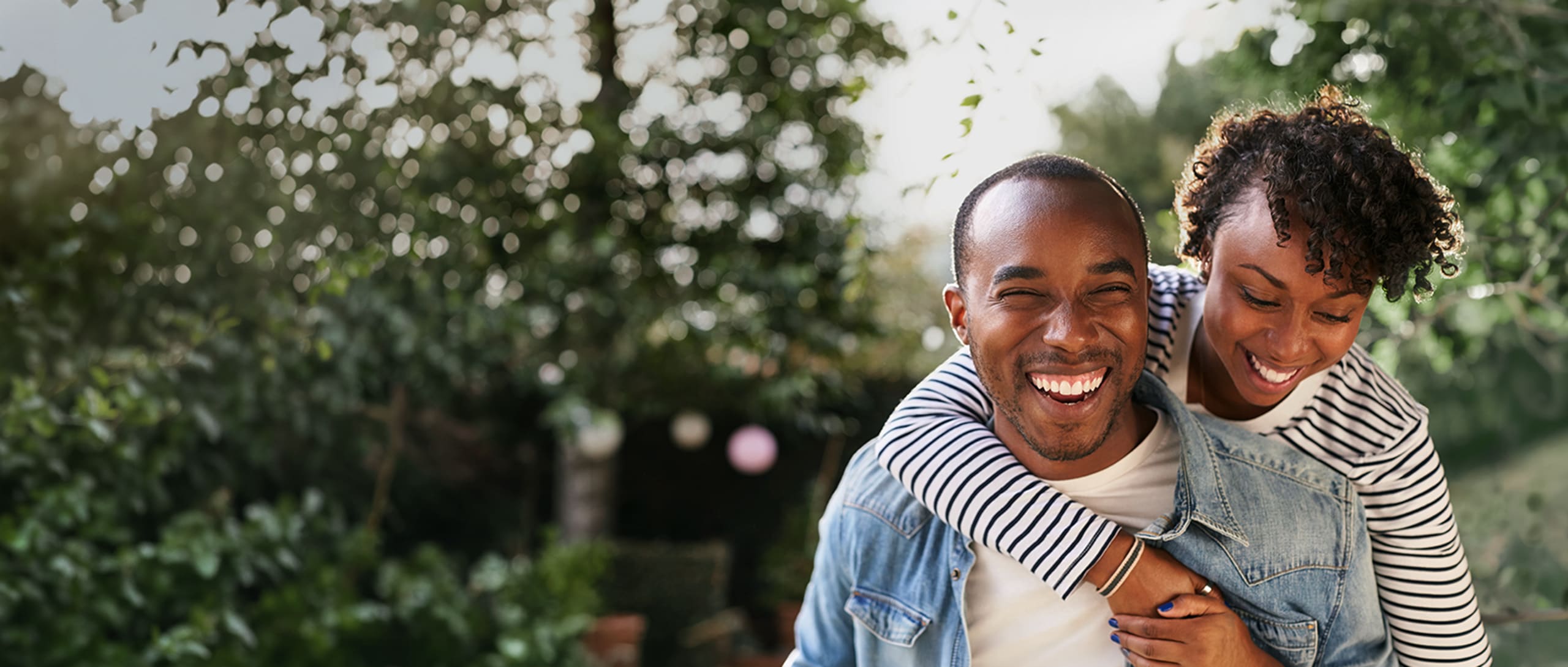 A man holding a woman on his back, smiling together.