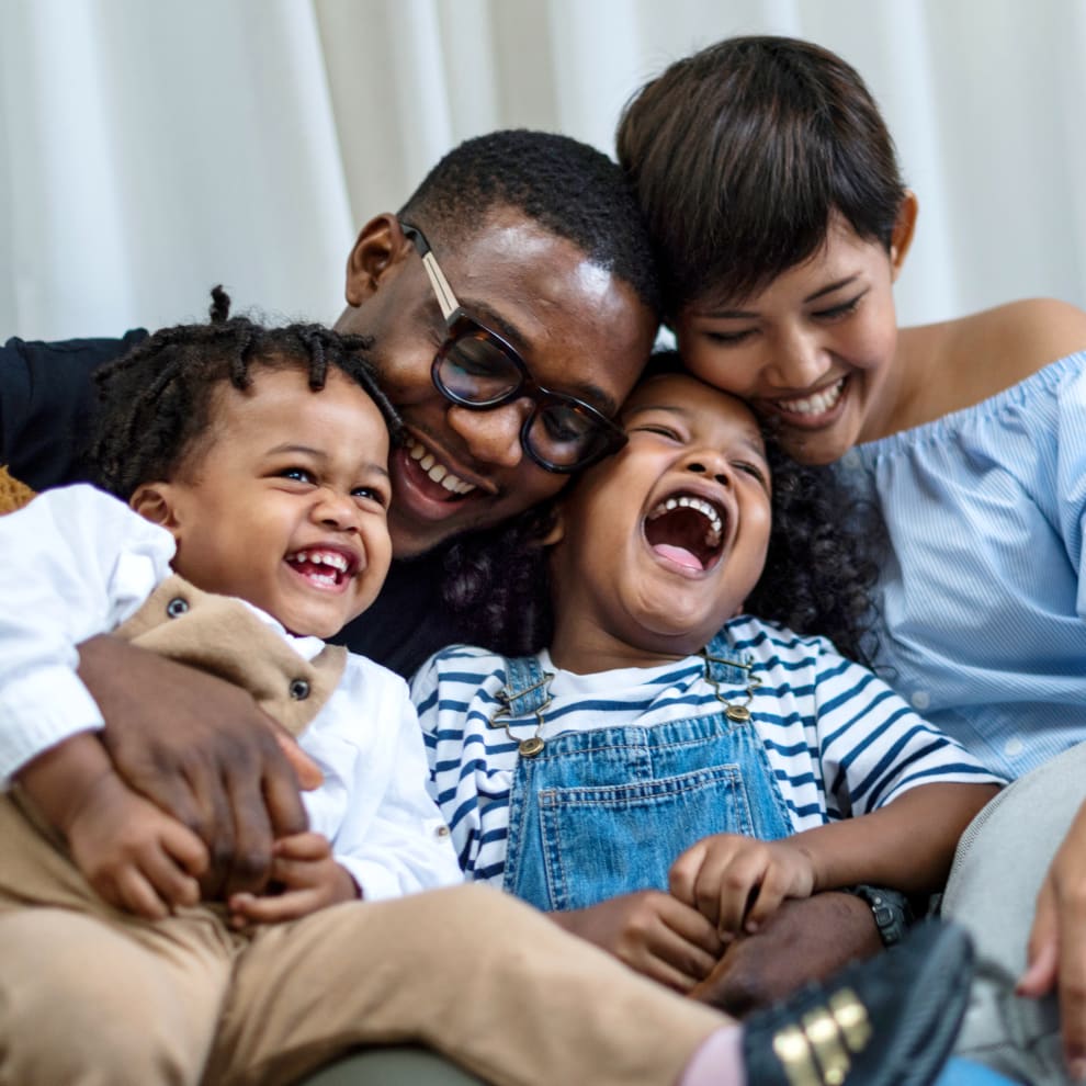 A family of four are smiling and laughing.