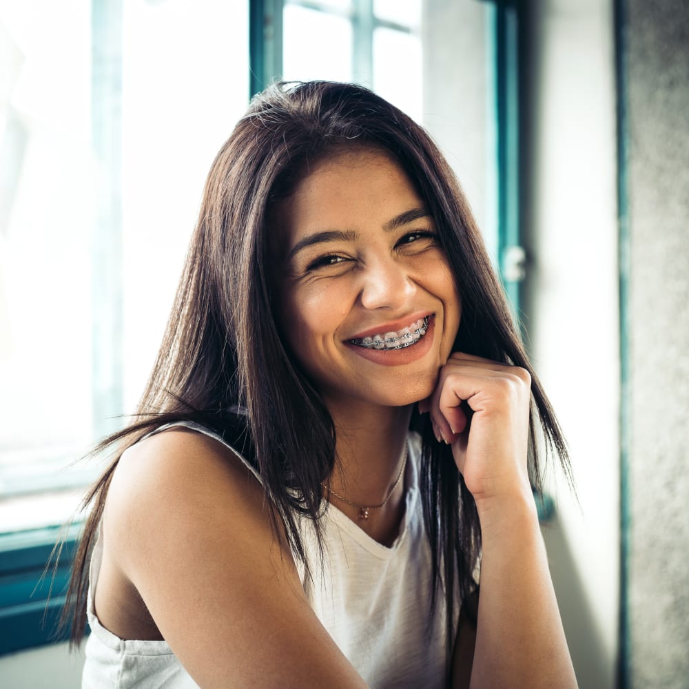 A girl is smiling, showing off her braces.