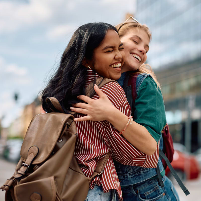 Two young women are hugging.